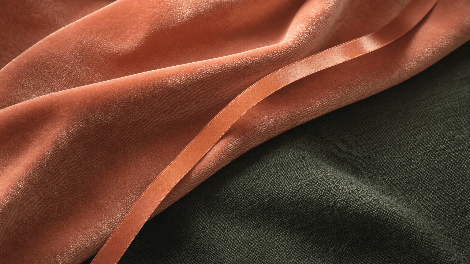 Dusty-coral velvet with a fine peach satin ribbon rising diagonally — a calm recovery texture