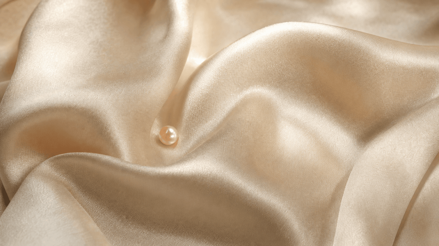 Ivory Seidensatin mit einer kleinen peach Perle in der zentralen Falte — ruhige intime Textur