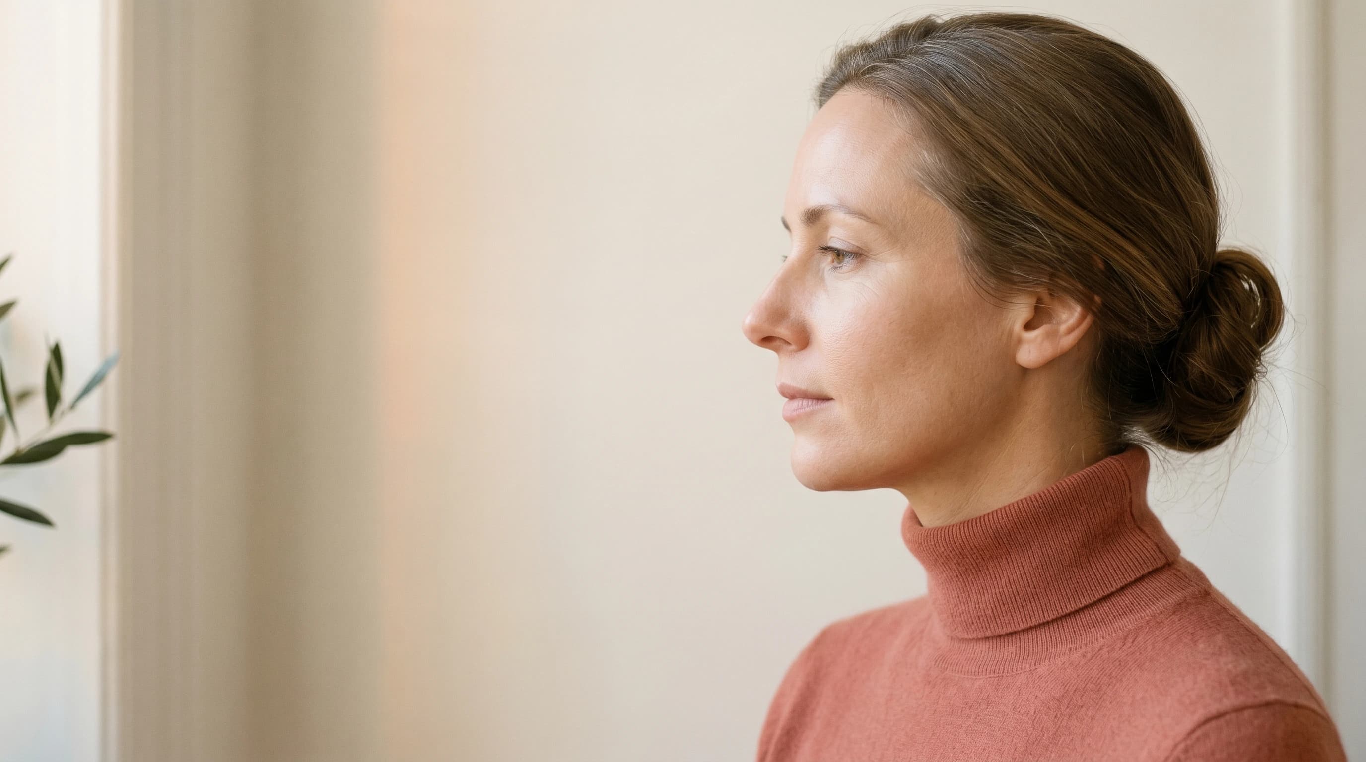 Editorial Profil mit geschlossenen, entspannten Lippen, dusty-coral Cashmere-Rollkragen — Praxis Ästhetik am Isartor München