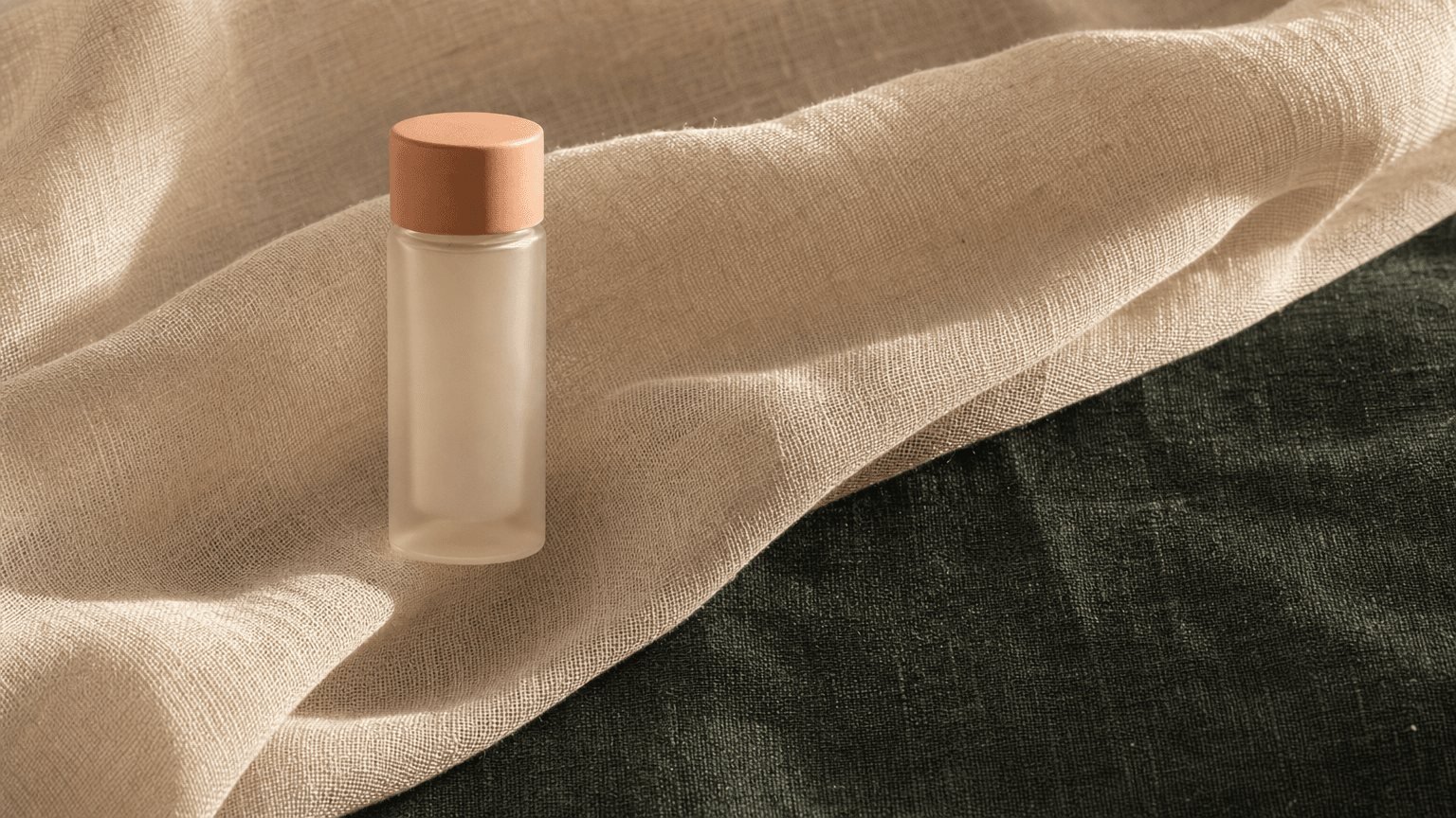 Kleines bone-cream Apotheker-Glasfläschchen mit peach Matte-Stopper auf bone-cream Chiffon — Symbol der Wirkstoff-Präzision