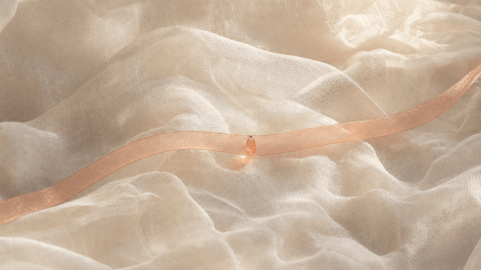Feines peach Organza-Band mit einer einzelnen peach Glas-Tropfen-Perle auf bone-cream Chiffon — gewichtslose Textur